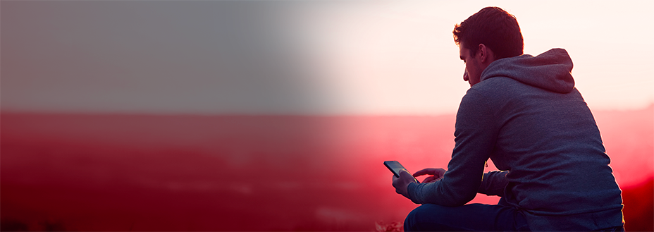 Adult man with looking at his phone texting 741741 for free mental health support.