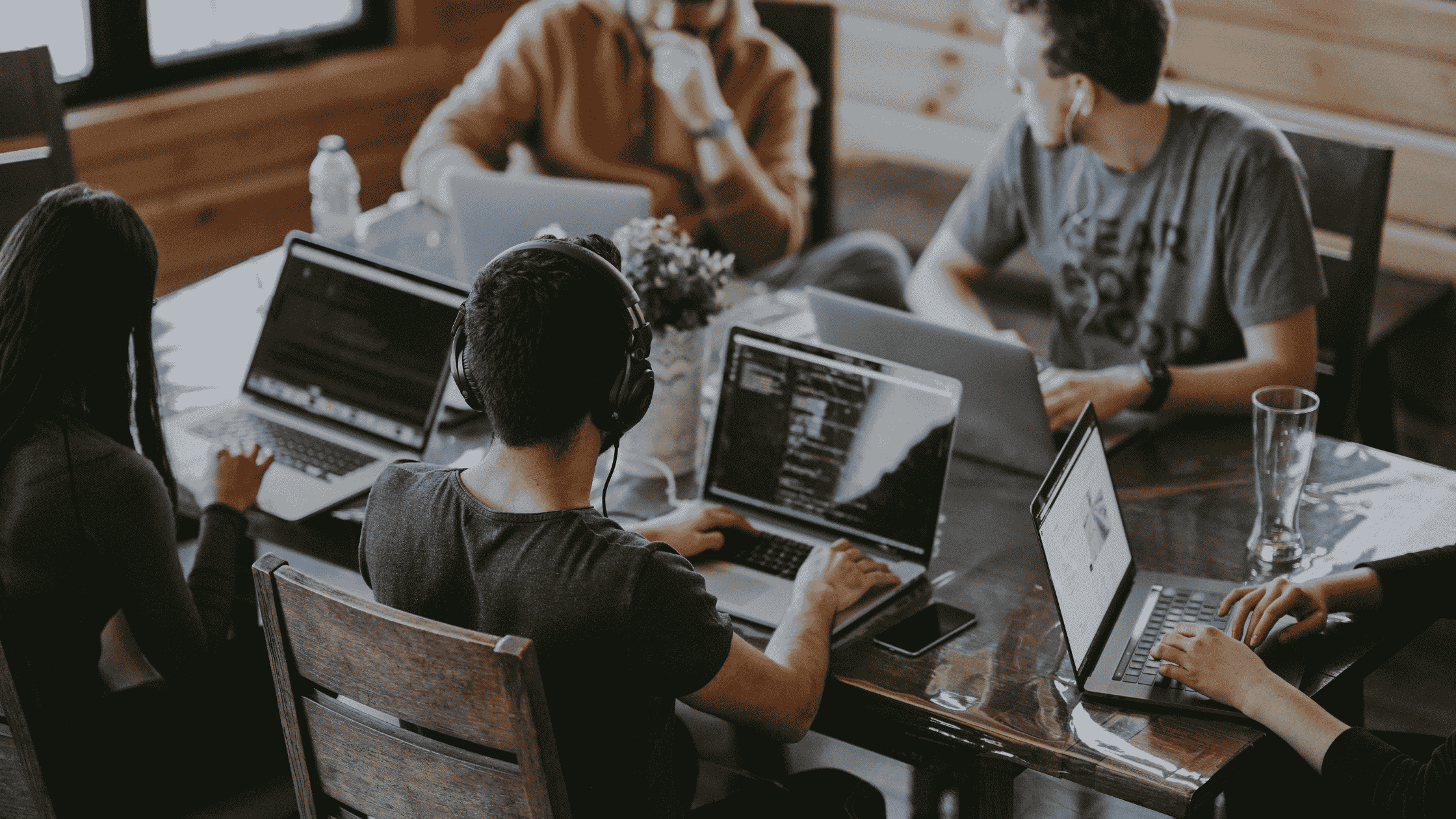 A group of diverse college students working on laptops at a shared table in a cozy space&mdash;showing how digital journaling prompts support student mental health and productivity